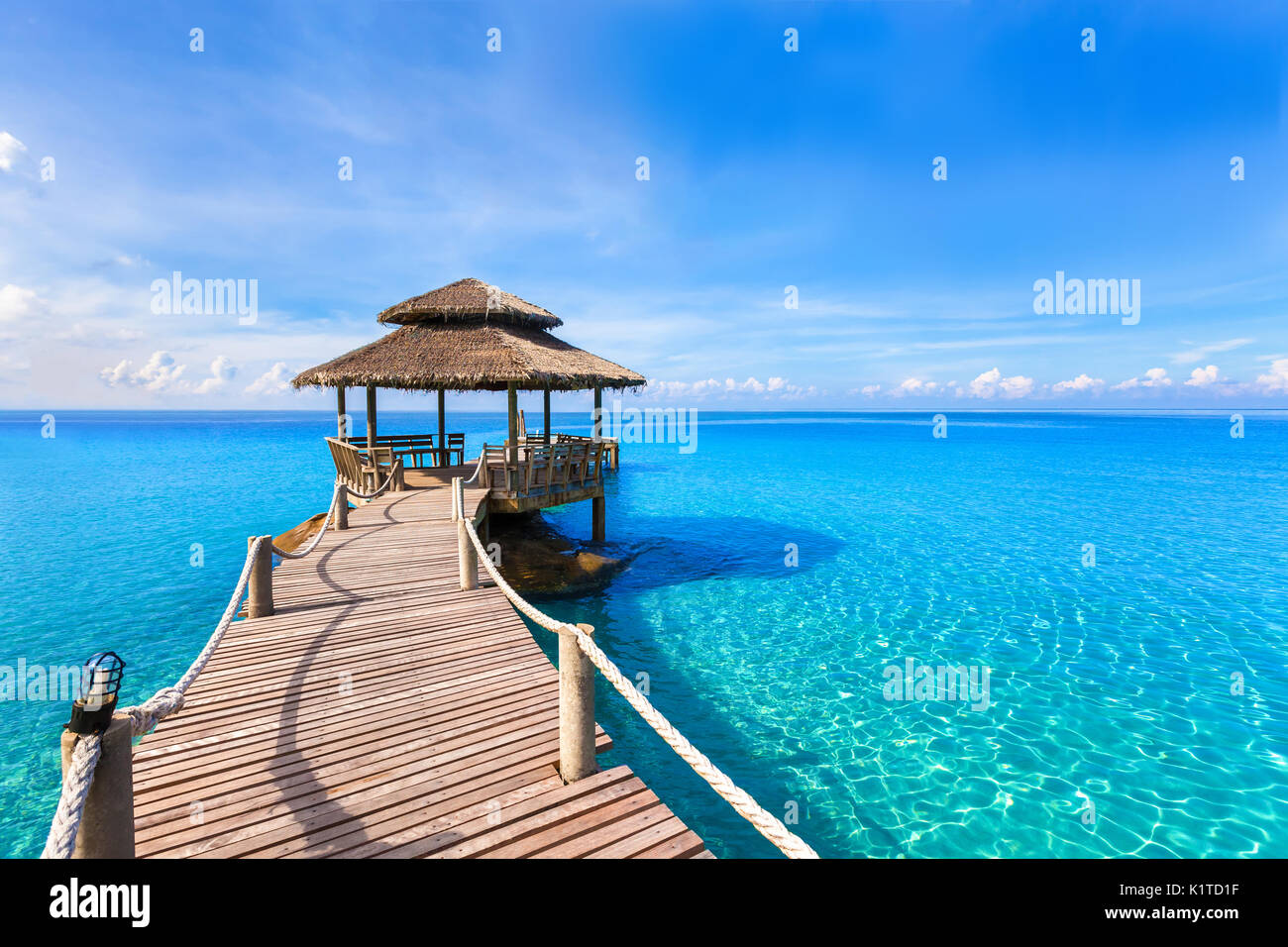 Schönen tropischen Sommer Strand Landschaft, luxuriöse Hotel hölzerne Seebrücke mit transparenten, türkisfarbene Meer Wasser Stockfoto