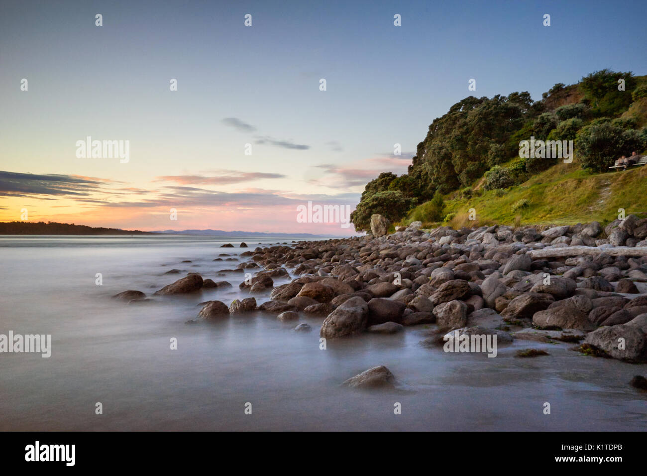 Lange Belichtung Landschaft Foto von Felsen bei Sonnenuntergang, Mt Maunganui, Neuseeland Stockfoto