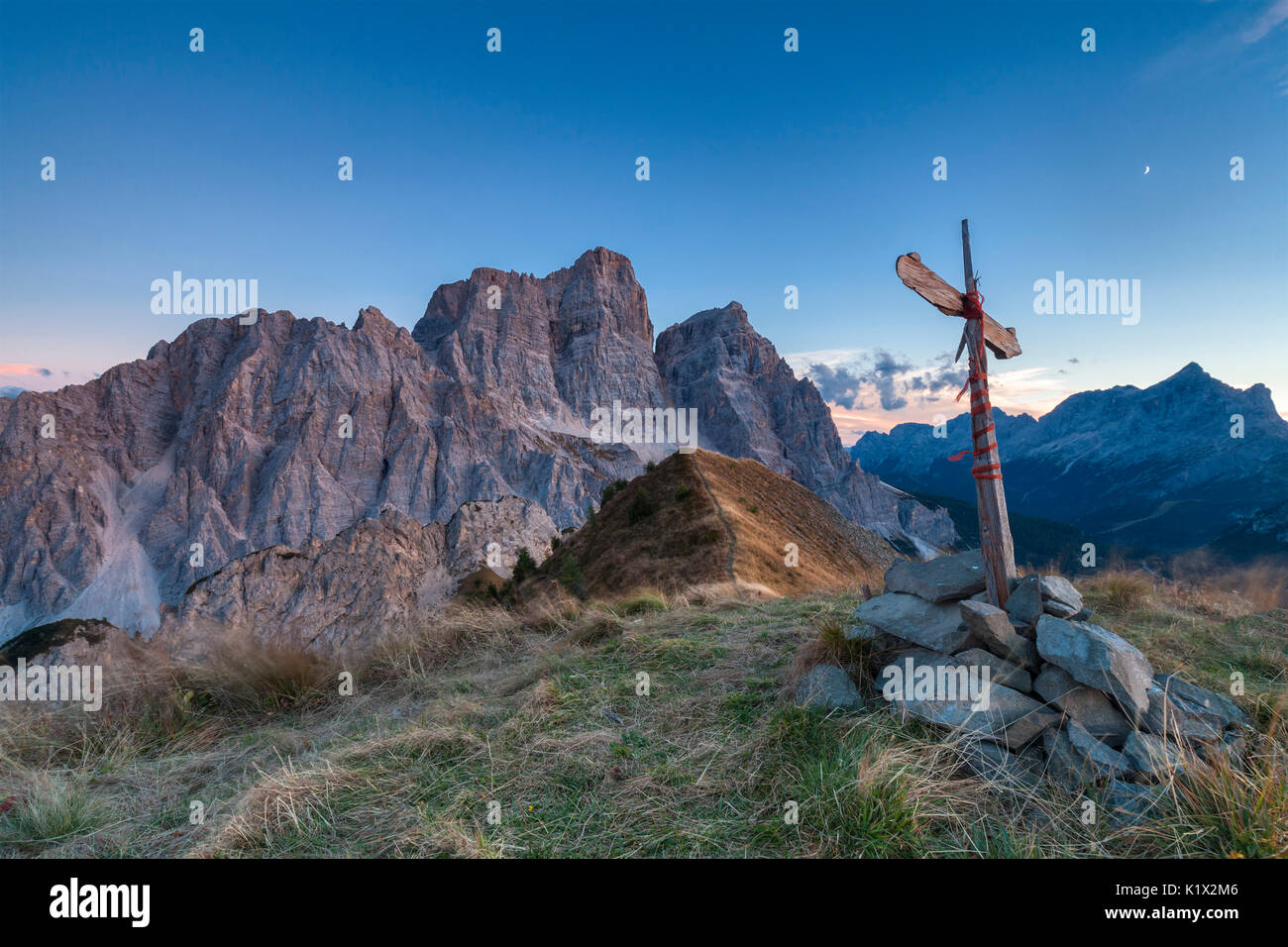 Europa, Italien, Venetien, Cadore. Das Gipfelkreuz auf dem Col de la Puina bei Sonnenuntergang mit Pelmo im Hintergrund Mount, Dolomiten Stockfoto