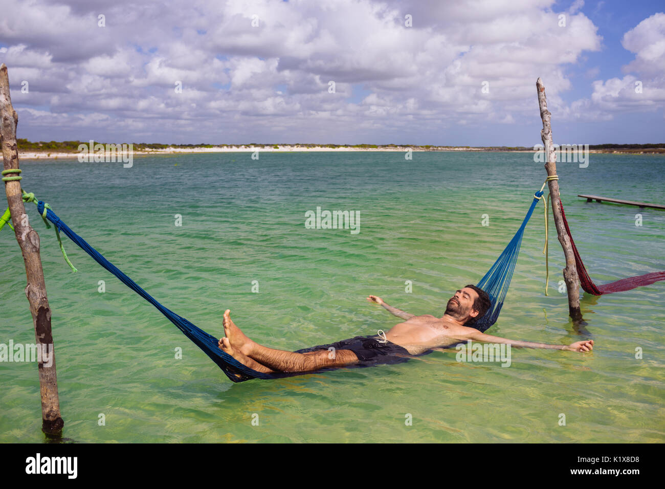 40 Jahre man Genießen und Entspannen in einer Hängematte in Lagoa Azul, Jericoacoara, Ceará, Brasilien Stockfoto