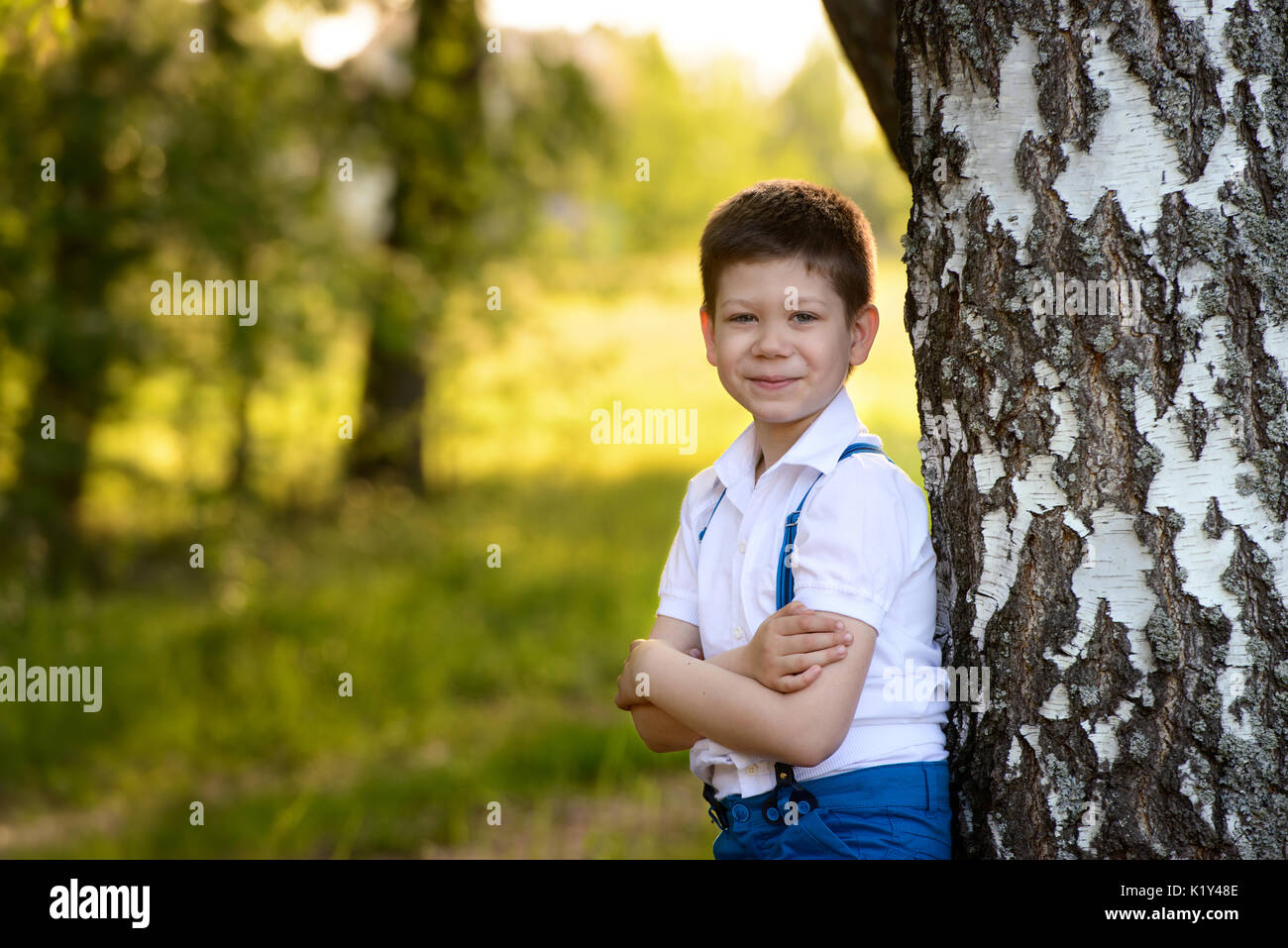 Portrait Junge in der Nähe der Baum im Park, faltete seine Hände vor ihm Stockfoto
