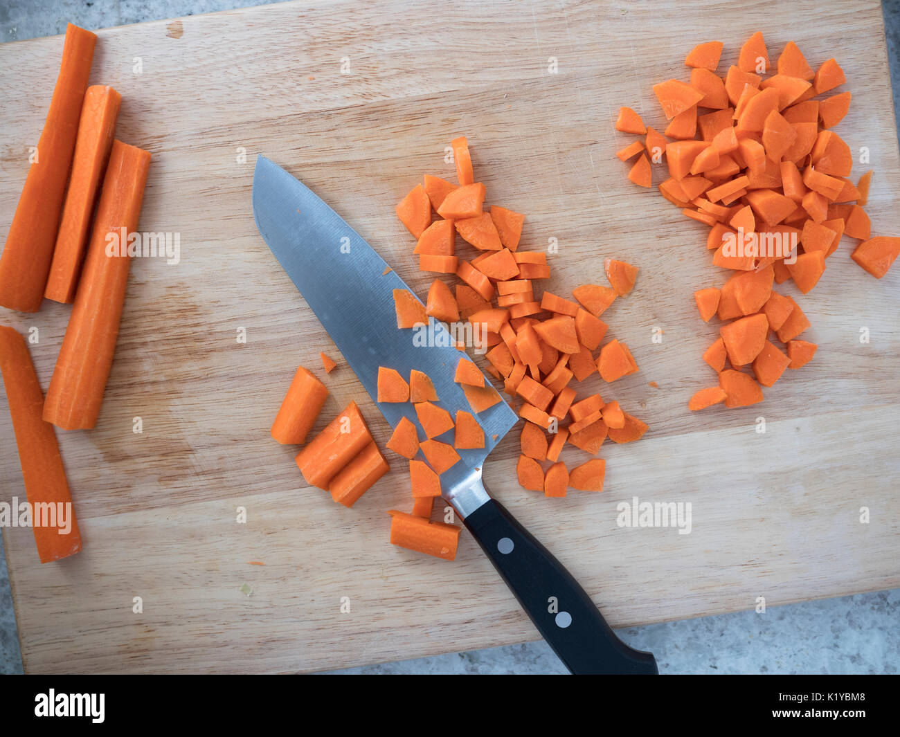 Carrot Sticks und gehackte Karotten auf Schneidebrett mit Messer. Stockfoto