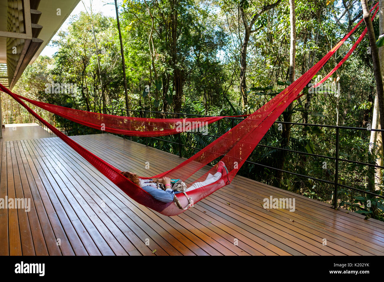 Menschen auf rot Hängematten auf der Tunga Galerie, Inhotim Kulturinstitut, Brumadinho, Belo Horizonte, Minas Gerais, Brasilien hängend ausruhen. Stockfoto