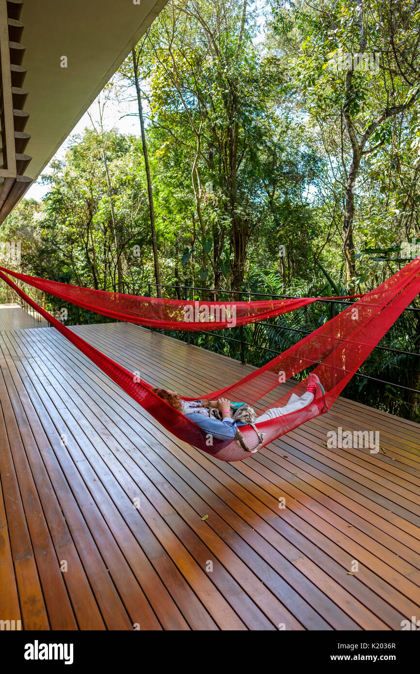 Menschen auf rot Hängematten auf der Tunga Galerie, Inhotim Kulturinstitut, Brumadinho, Belo Horizonte, Minas Gerais, Brasilien hängend ausruhen. Stockfoto