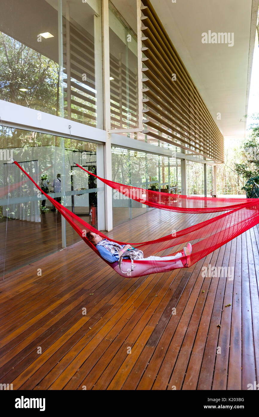 Menschen auf rot Hängematten auf der Tunga Galerie, Inhotim Kulturinstitut, Brumadinho, Belo Horizonte, Minas Gerais, Brasilien hängend ausruhen. Stockfoto