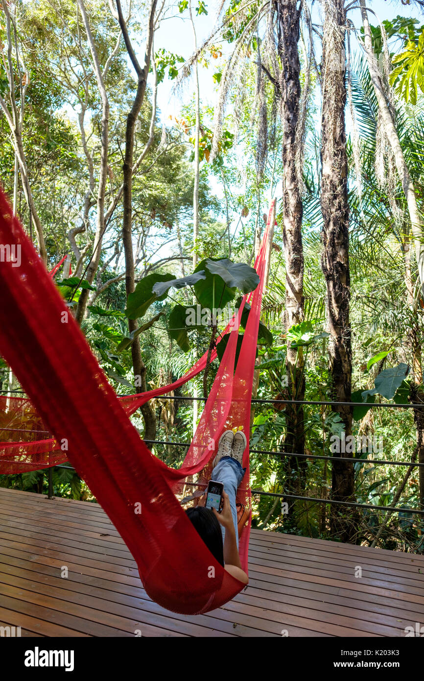 Menschen auf rot Hängematten auf der Tunga Galerie, Inhotim Kulturinstitut, Brumadinho, Belo Horizonte, Minas Gerais, Brasilien hängend ausruhen. Stockfoto