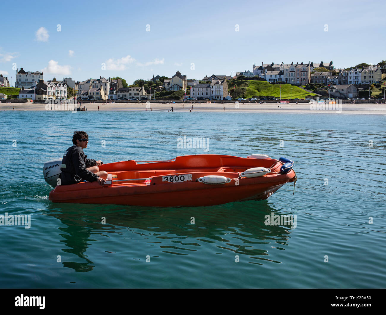 Mann in einem orange Rippe ankommen Hafen in Port Erin auf Stockfoto