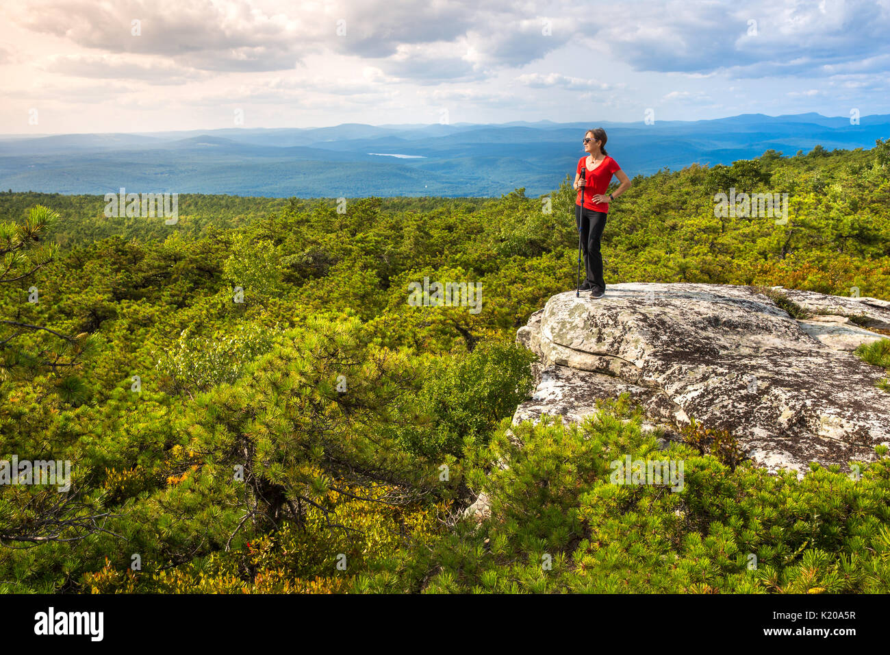 Frauen steht am Rand einer Klippe und genießt die Natur am höchsten Punkt, oben auf Shawangunk Ridge, in Upstate New York. Stockfoto