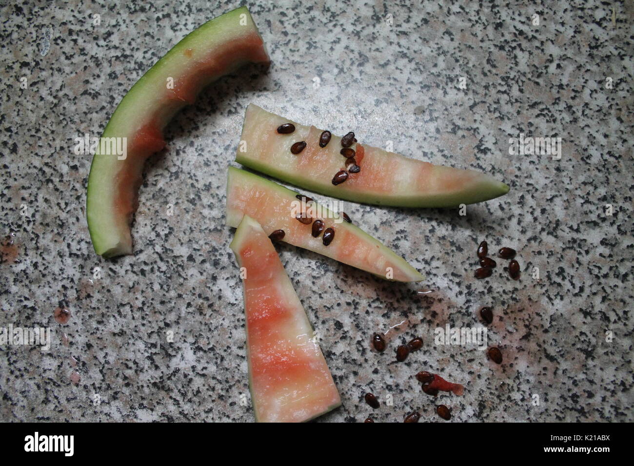 Kruste grüne Rollen der Wassermelone abgedeckt süßen Saft und Samen nach der Mahlzeit Stockfoto