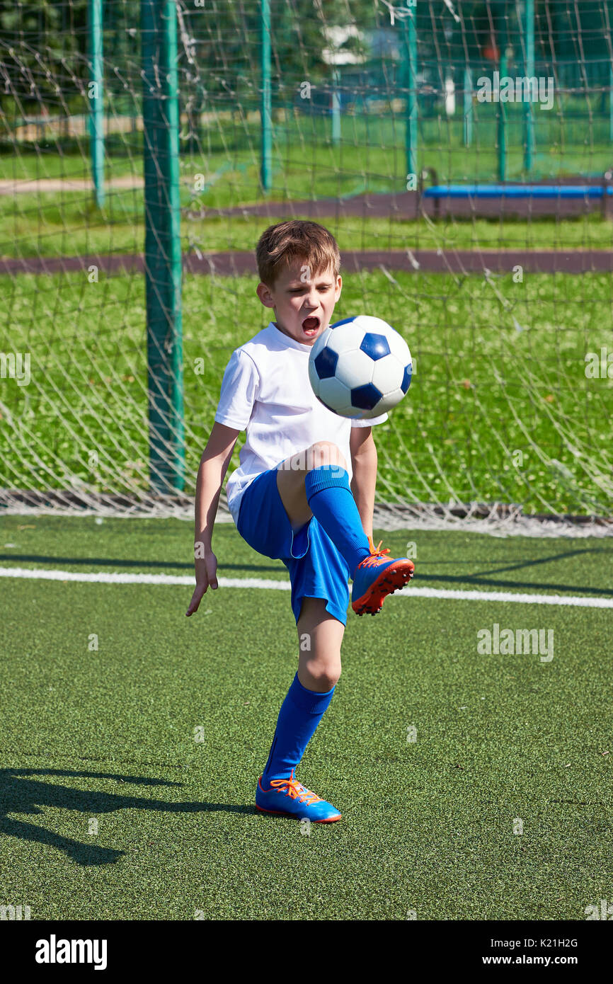 Junge Fußball-Training mit einen Ball auf dem grünen Rasen des stadiumм Stockfoto
