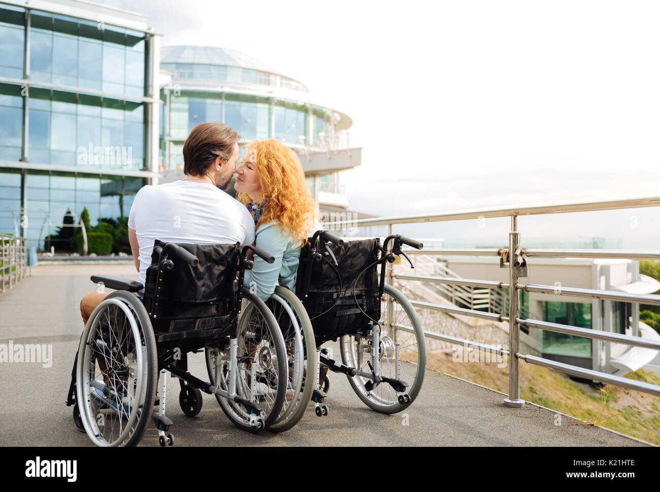 Rückansicht eines Senior wheelchaired Paar küssen Stockfoto