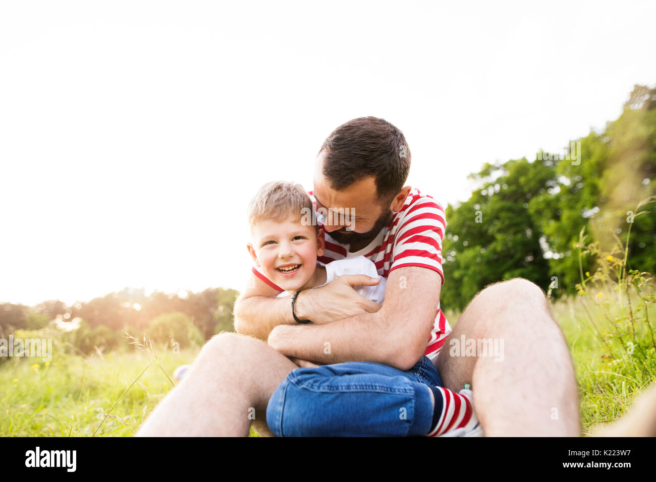 Hipster Vater und kleinen Sohn auf der grünen Wiese. Sonnigen Sommertag. Stockfoto