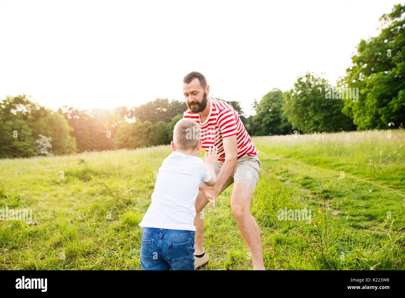 Hipster Vater und kleinen Sohn auf der grünen Wiese. Sonnigen Sommertag. Stockfoto