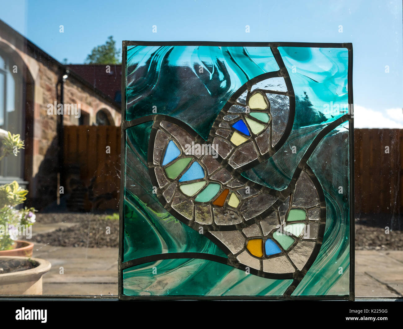 Glasmalerei Arbeiten der Abstrakten natürliche Formen mit Meer Stücke aus Glas, mit Kupferfolie und Blei kam Löttechniken, beleuchtet durch Sonnenlicht Stockfoto