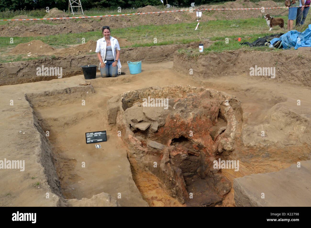 2017 Aylsham römischen Projekt - Archäologe kniend Neben ausgegraben Römischer brennofen am letzten Tag der Graben, mit site Code signieren und nordpfeil an Stelle Stockfoto