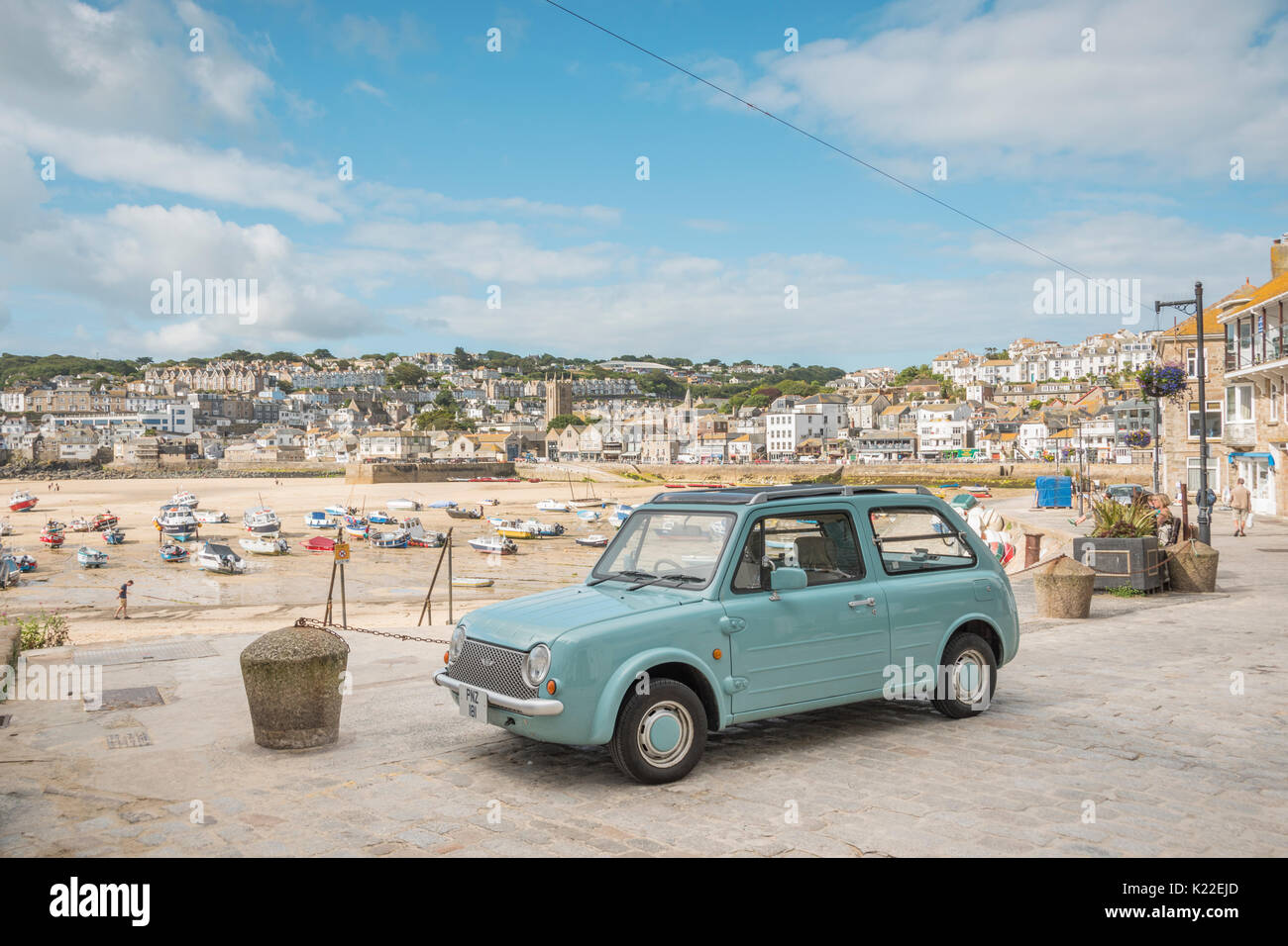 Einen alten Nissan Pao auf der Hafenseite in St. Ives, Cornwall, England, Großbritannien geparkt Stockfoto