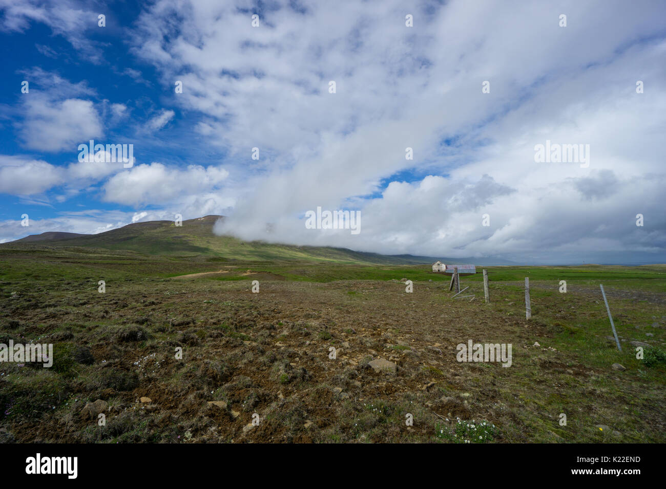 Island - weite grüne Landschaft mit alten Zaun und alte Scheune auf grünen Wiesen Stockfoto