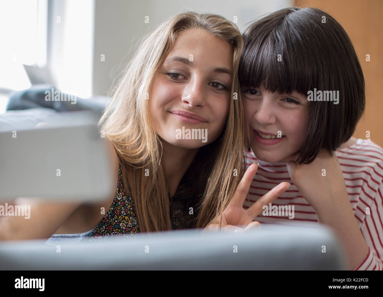 Zwei Mädchen im Teenageralter die Selfie im Schlafzimmer zu Hause Stockfoto