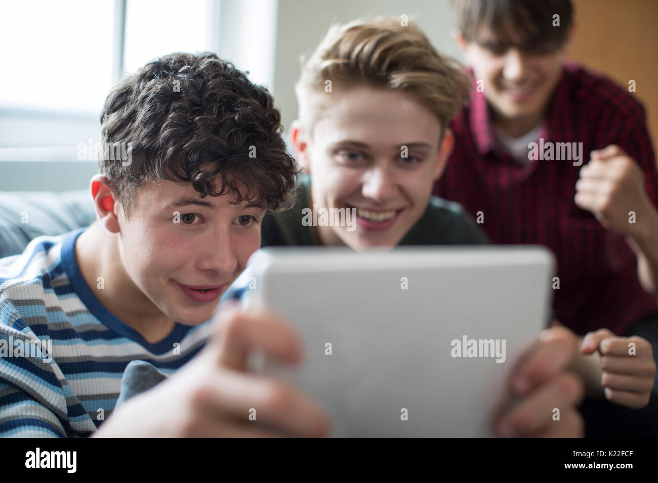 Drei Jungs im Teenageralter Spiel auf Digital Tablet zu Hause Stockfoto