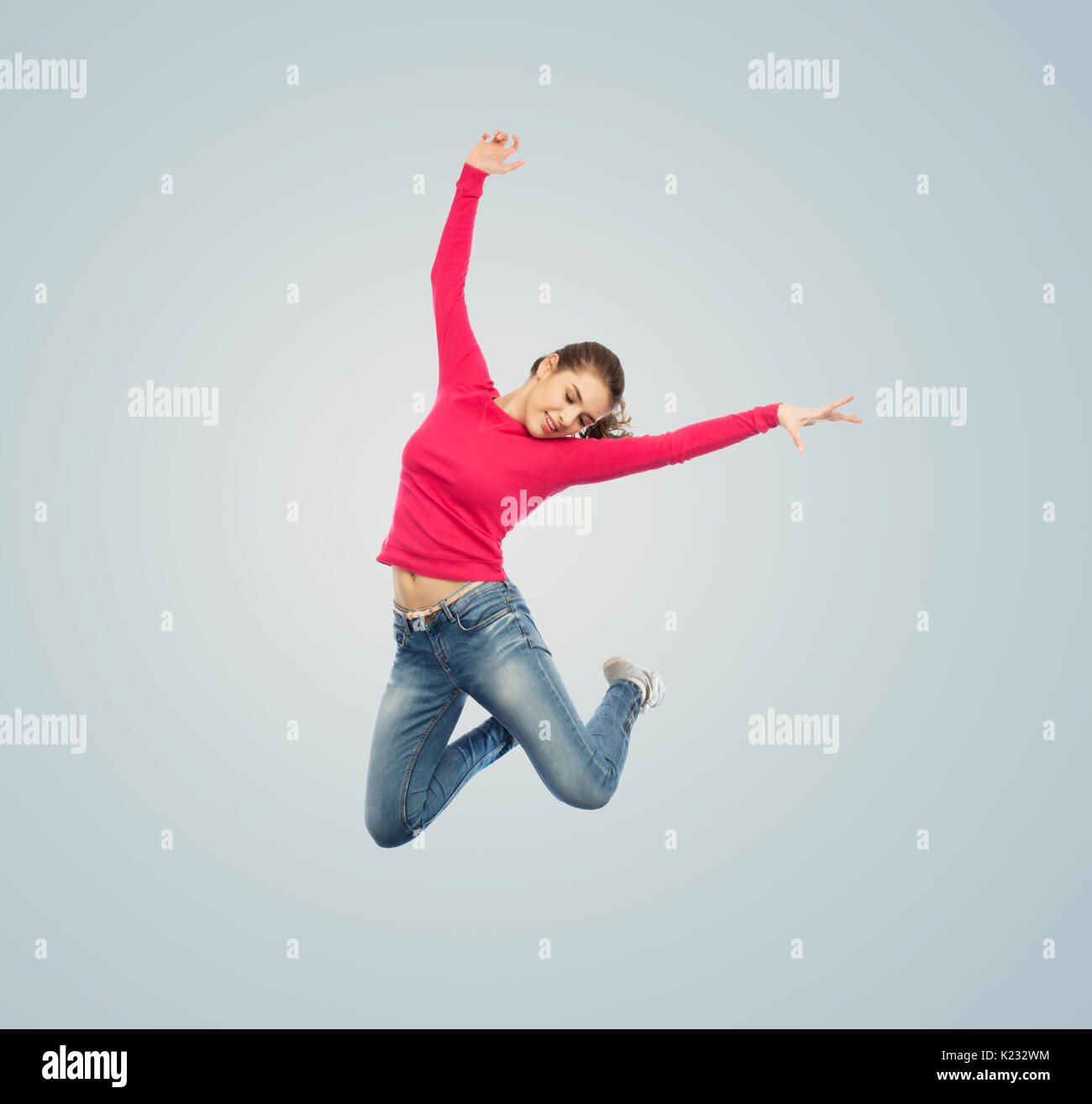 glückliche junge Frau in die Luft springen oder tanzen Stockfoto