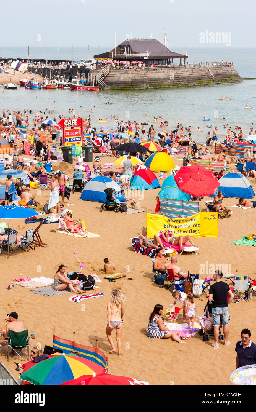 England, Viking Bay, Broadstairs. Strand überfüllt mit Asylbewerbern während der heißen Wetter. Strand, den Hafen und das Meer im Blick, Massen von Menschen am Strand. Strahlender Sonnenschein. Stockfoto