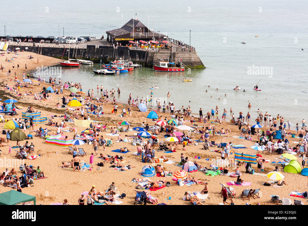 England, Viking Bay, Broadstairs. Strand überfüllt mit Asylbewerbern während der heißen Wetter. Strand, den Hafen und das Meer im Blick, Massen von Menschen am Strand. Strahlender Sonnenschein. Stockfoto