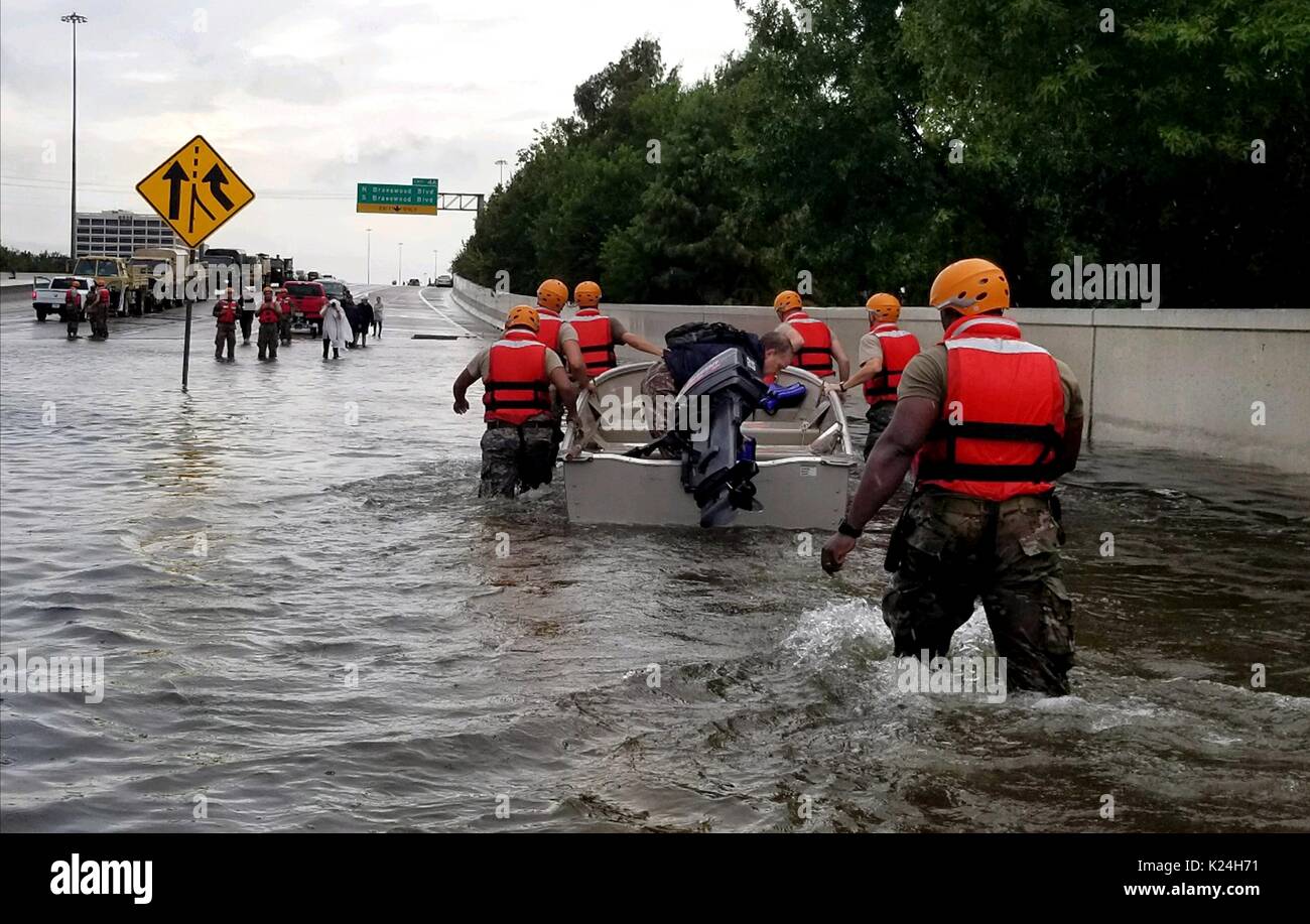 Der nationalgarde verwenden Sie ein Boot für die gestrandeten Bewohner auf der Suche nach massive Überflutungen aus Regen überschwemmt Straßen und Gebäude in der ganzen Stadt in die Folgen des Hurrikans Harvey 28. August 2016 in Houston, Texas. Stockfoto