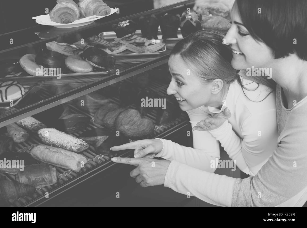 Mädchen und Frau gerne Auswahl Gebäck in der Bäckerei Stockfoto