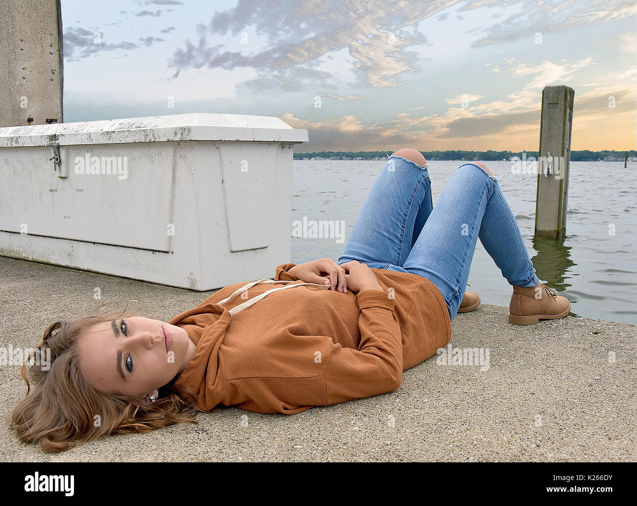 Teenage girl Horizontalen auf Marina dock durch Wasser Stockfoto