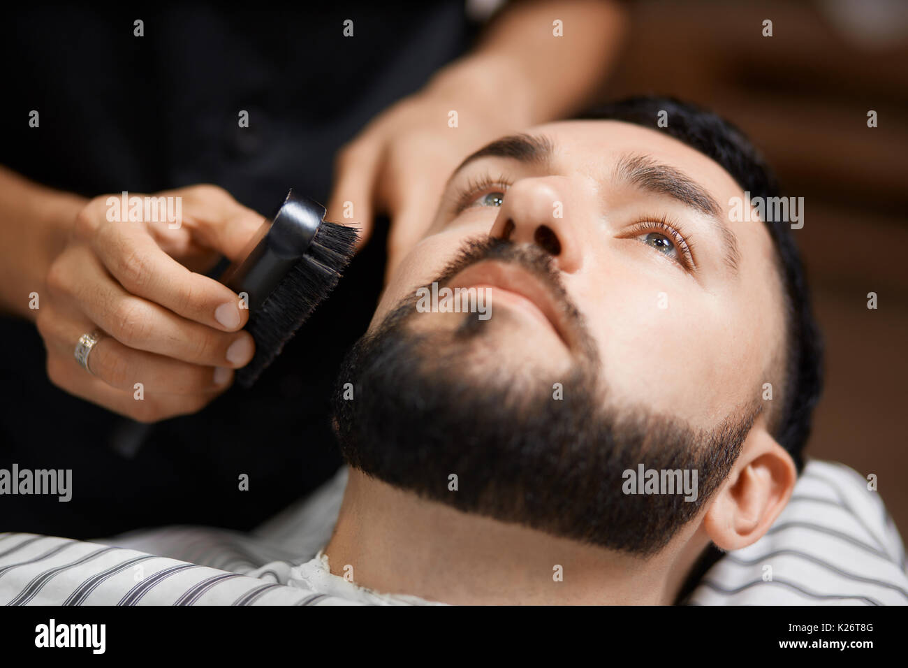 Hairtylist kämmen Sie Brot für Client Barbershop. Stockfoto