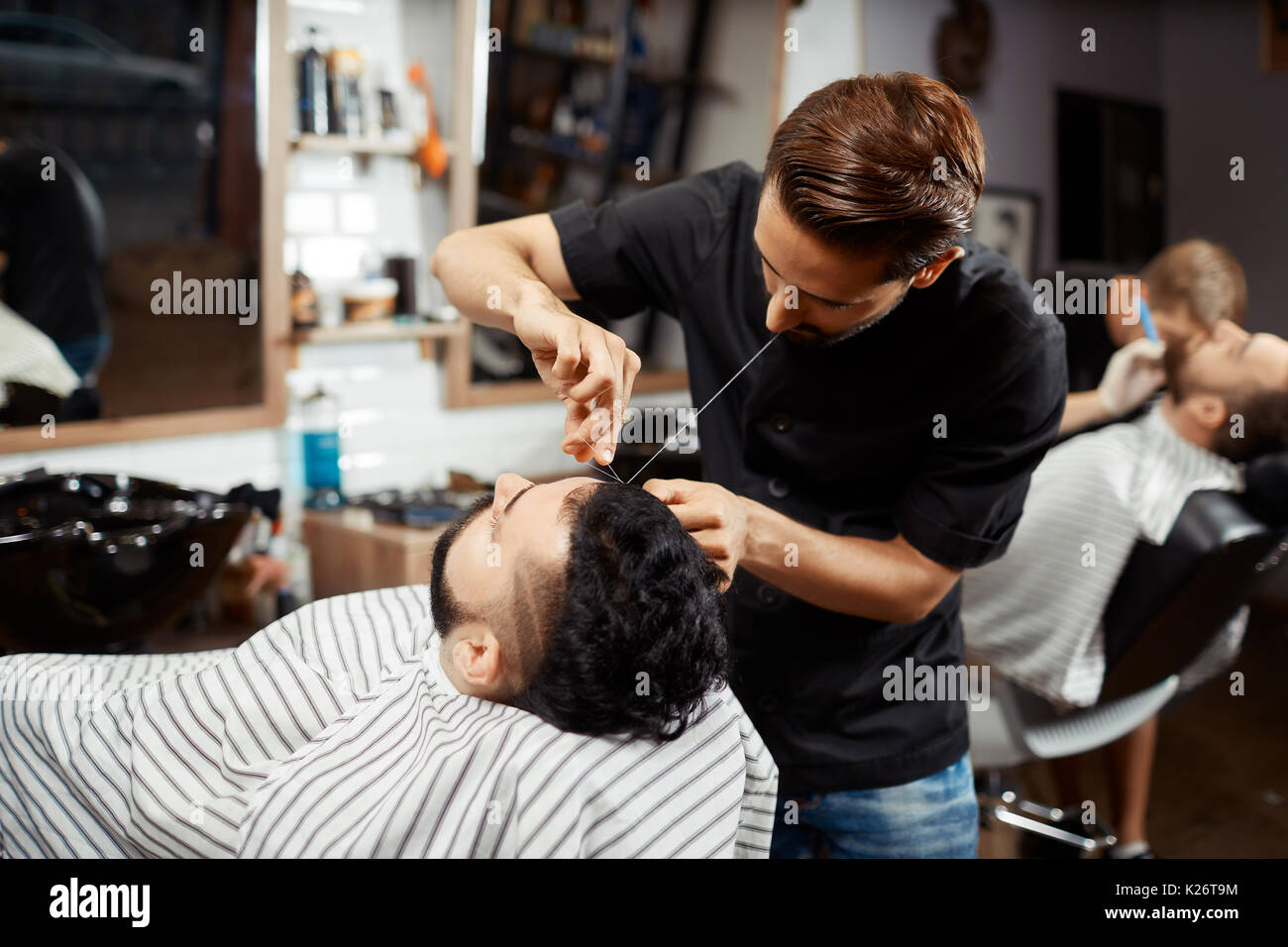 Friseur, Korrektur und Schneiden von Brot in der modernen Barbershop. Stockfoto
