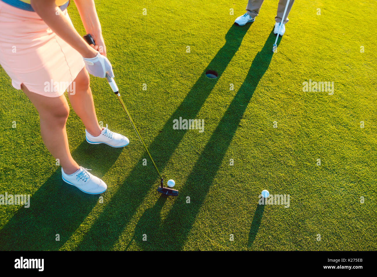 Frau Spieler bereit, den Ball in das Loch am Ende eines zu schlagen Stockfoto