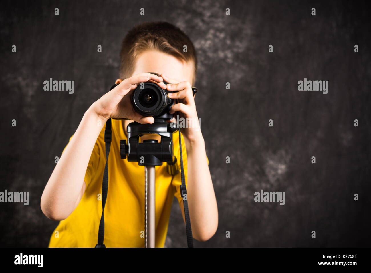 Junge Fotograf mit der Kamera auf einem Stativ betriebsbereit, Stockfoto