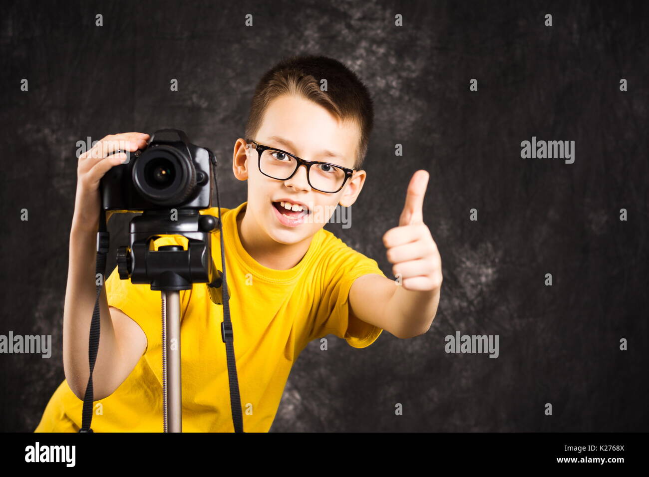 Junge Fotograf mit der Kamera auf einem Stativ betriebsbereit, Stockfoto