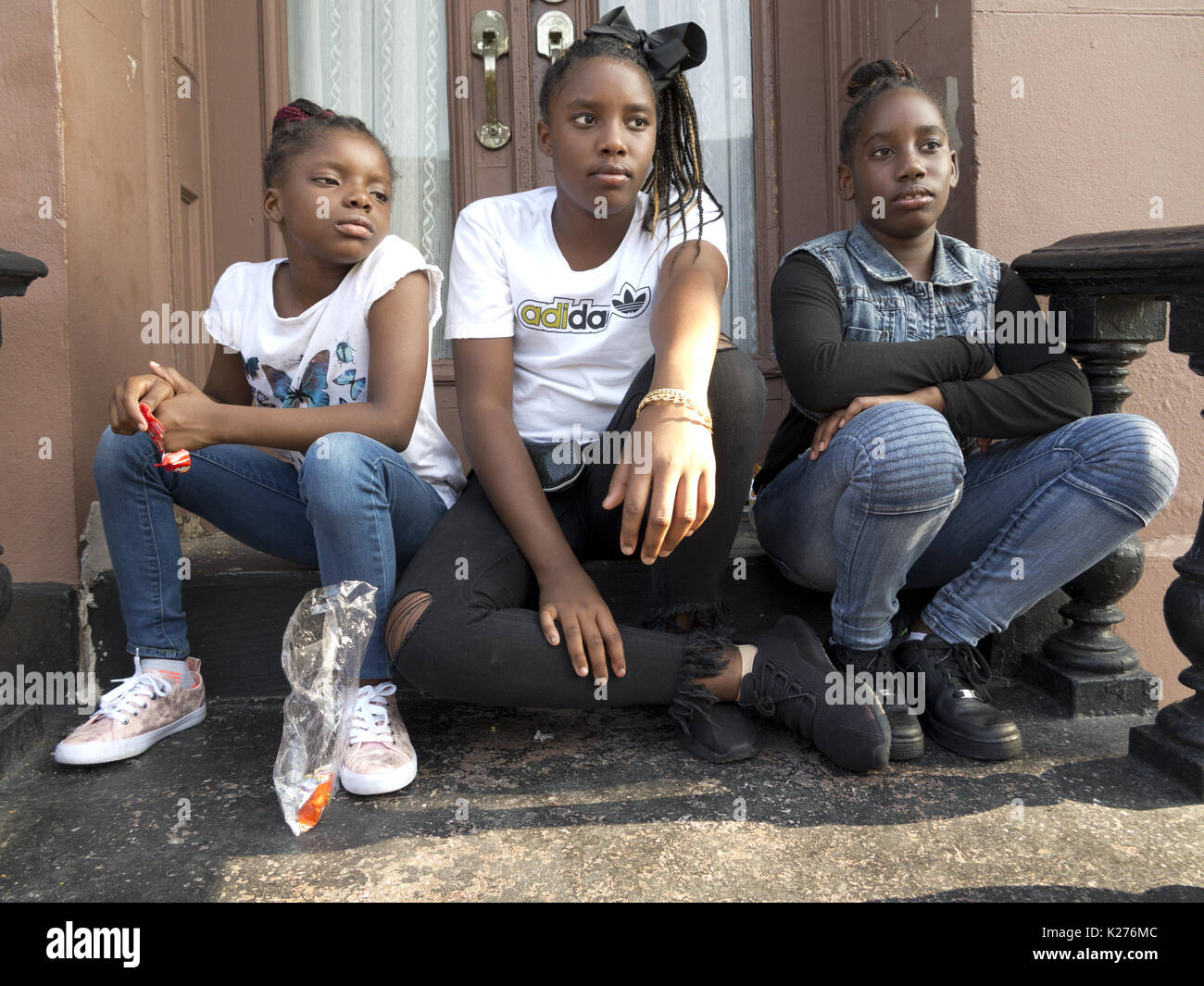 Mädchen auf Stoop in der Bedford Stuyvesant Abschnitt von Brooklyn, NY, 26.08.2017. Stockfoto