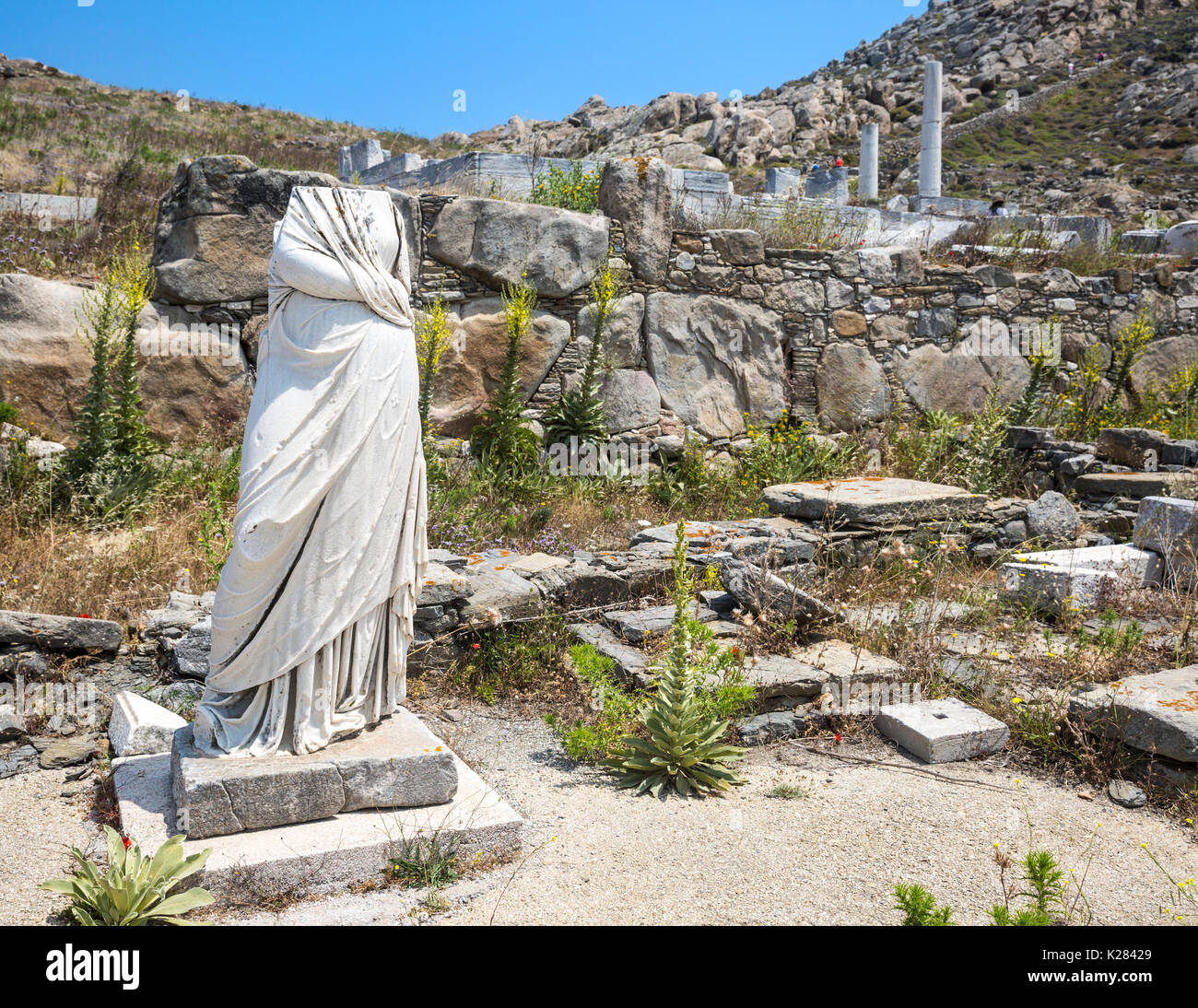 Kopflose Statue steht man inmitten der Ruinen von Delos, Kykladen, Griechenland. Stockfoto