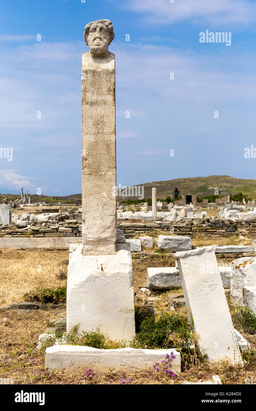 Verwittertem Marmor Spalte mit einem Kopf oben inmitten der archäologischen Ruinen, Delos, Griechenland Stockfoto