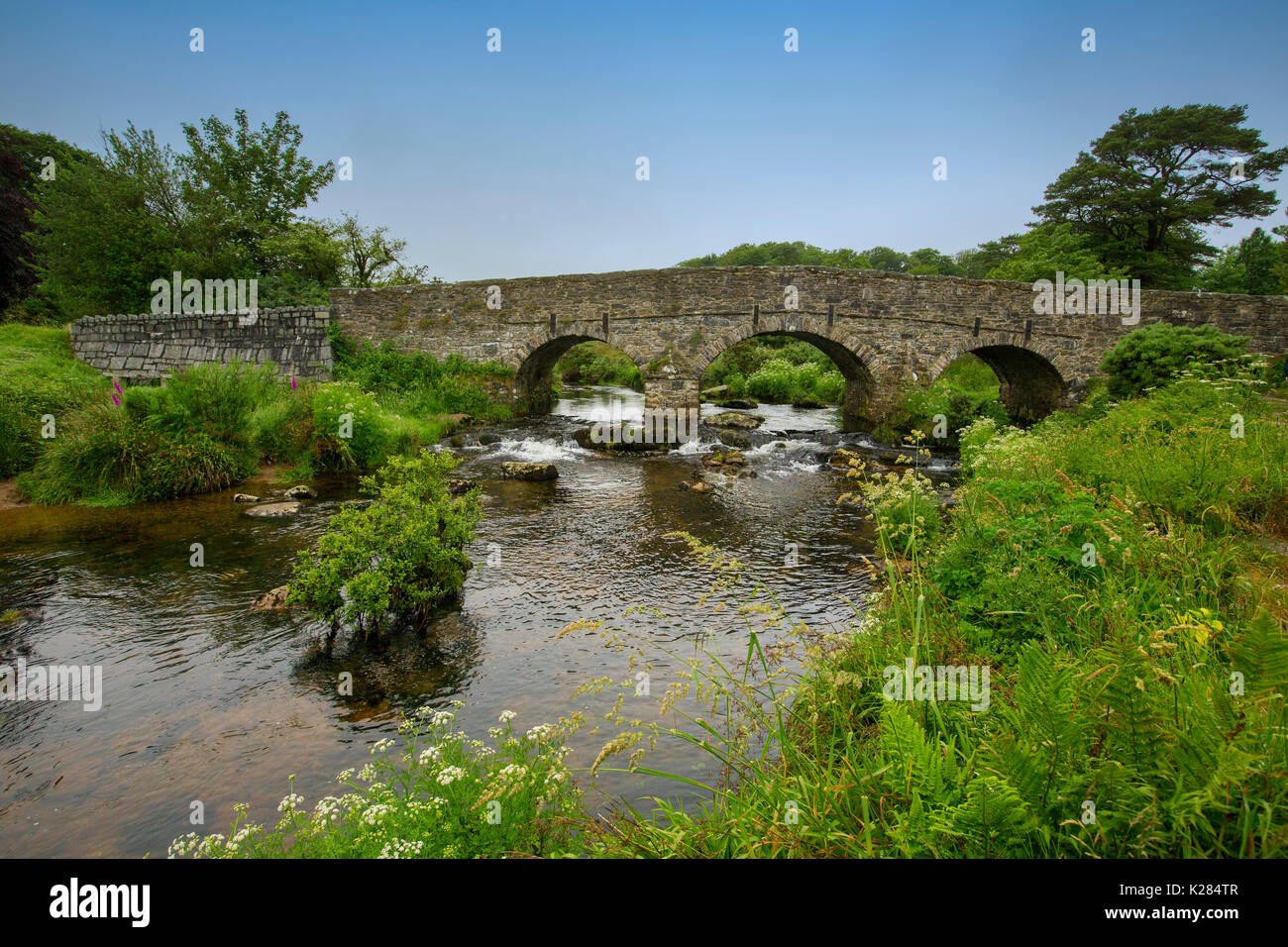 Weltkulturerbe 18. Jahrhundert gewölbten Steinbrücke über die East Dart, Nebenfluss des Flusses Dart, in der Nähe der Ortschaft Postbridge, Dartmoor National Park, England Stockfoto