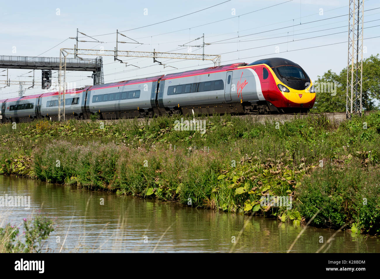 Virgin Trains Pendolino auf der West Coast Main Line neben der Oxford Canal, Ansty, Warwickshire, Großbritannien Stockfoto