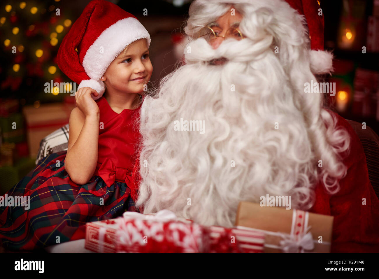 Süße Mädchen sitzen auf der Santa Knie Stockfoto