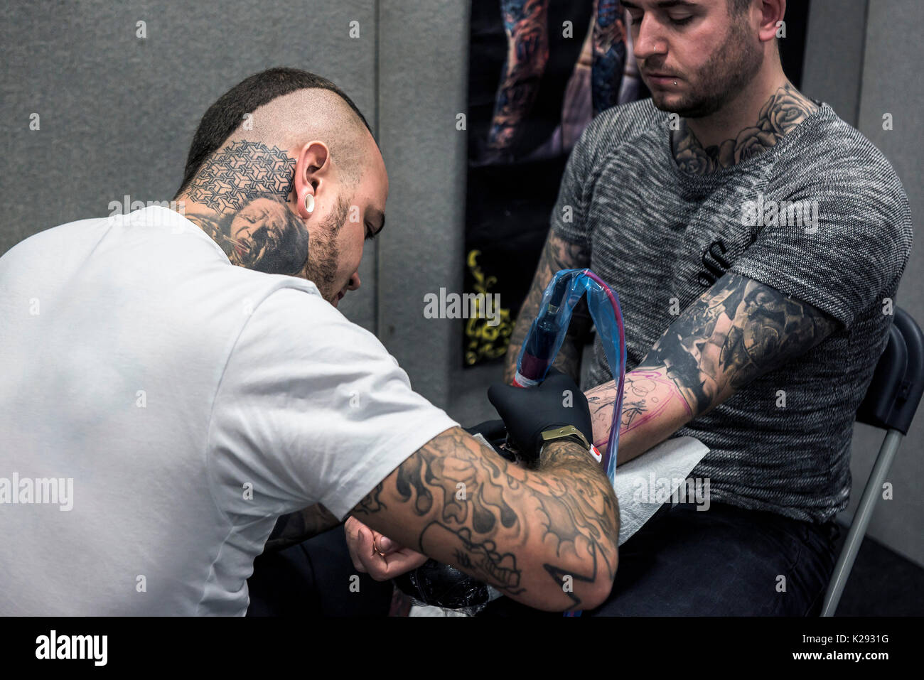 Cornwall Tattoo Convention - ein Tattoist Tätowierung der Unterarm eines Kunden bei der Cornwall Tattoo Convention. Stockfoto