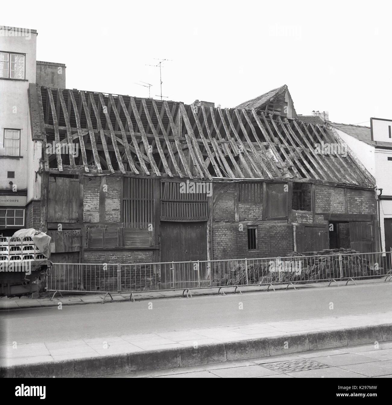 1960, historische, Bild zeigt die Außenansicht eines alten Ziegel storage Scheune in einer englischen Kleinstadt mit einer unsicheren Dach gebaut, seine alten hölzernen Sparren auf die Elemente ohne Fliesen oder Abdeckungen, England, Großbritannien ausgesetzt sind. Stockfoto