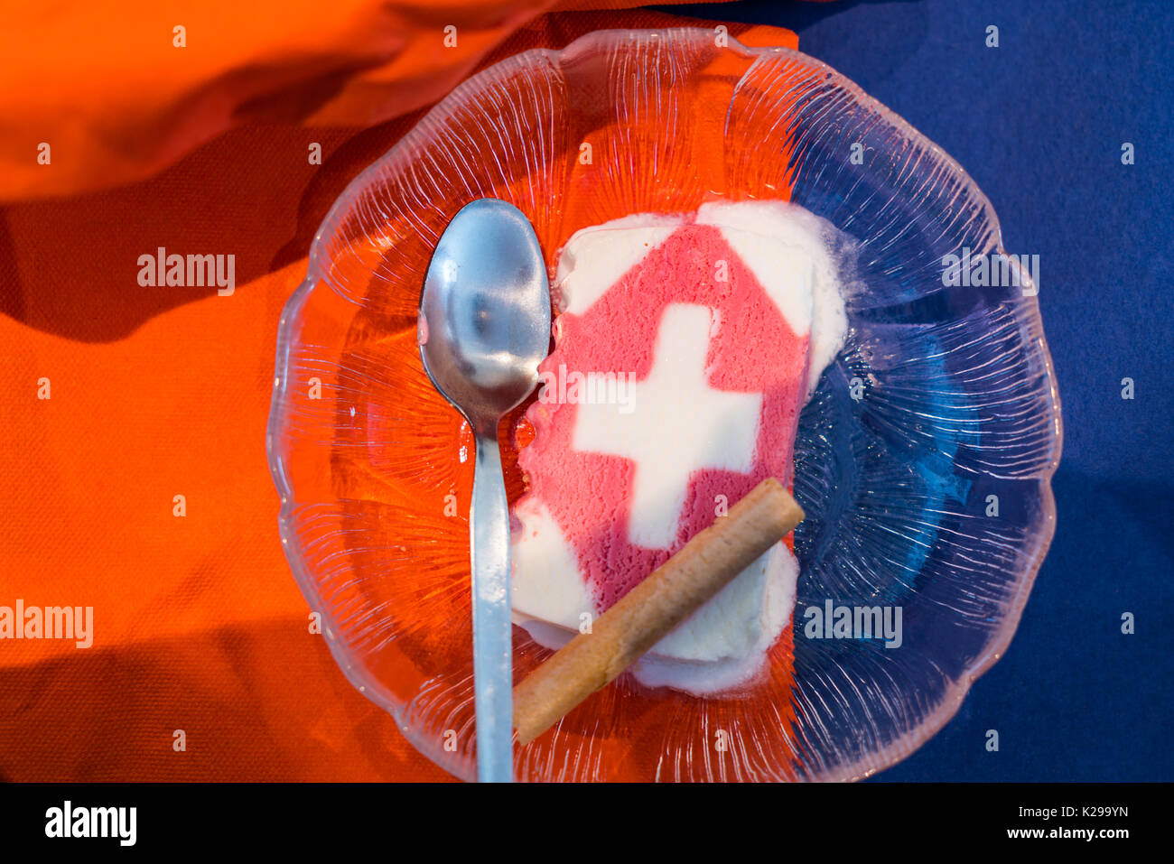 Köstliches Eis mit Schweizer Flagge und Metalllöffel auf einer Glasplatte, serviert in Jungfrau, Schweiz. Stockfoto