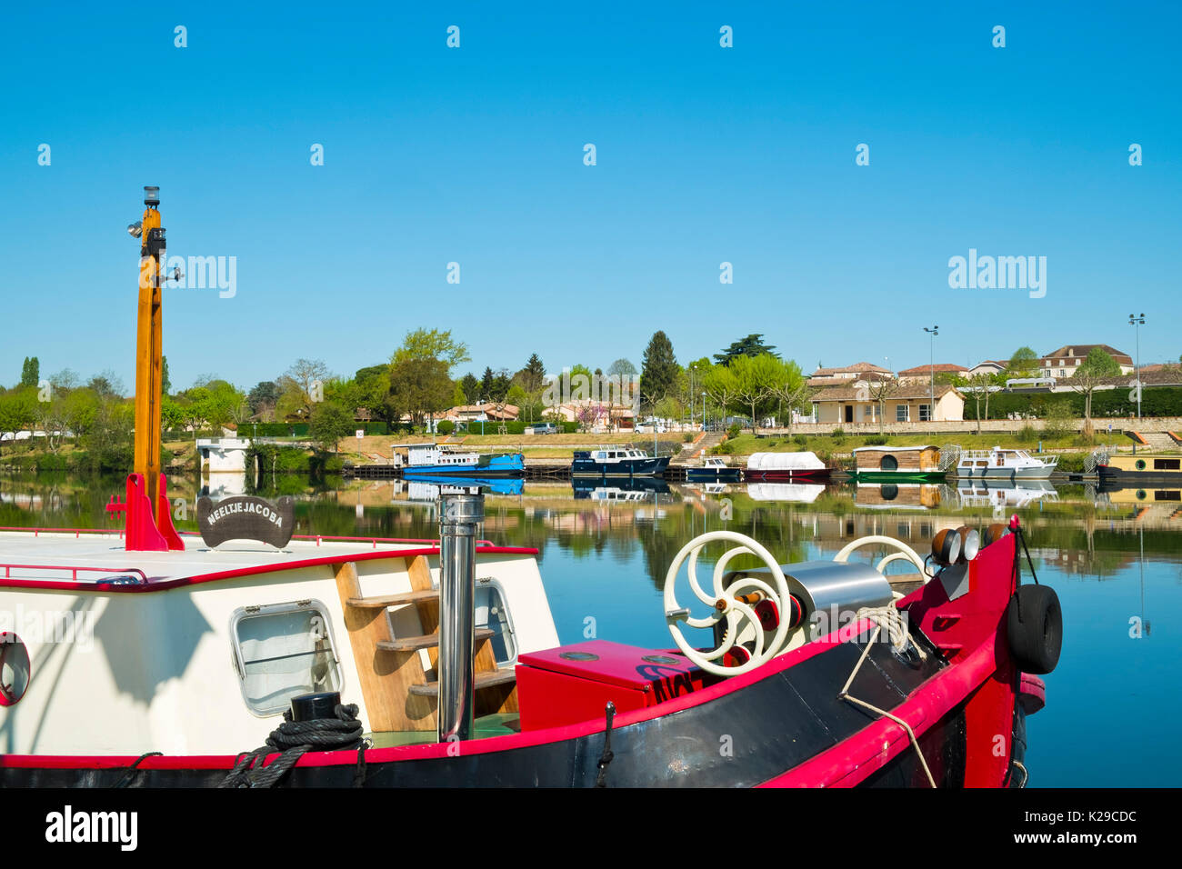 Blick über den ruhigen Fluss Lot in Richtung St-Sylvestre-sur-Lot, Lot-et-Garonne, Frankreich von Port de Penne (Penne d'Agenaise) in herrlichen Frühlingssonne. Stockfoto