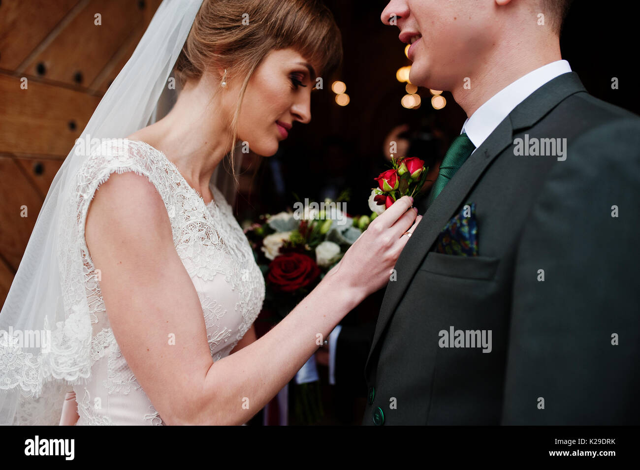 Schöne Braut pinning ein knopfloch Blume bis zu einem Bräutigam Jacke. Stockfoto