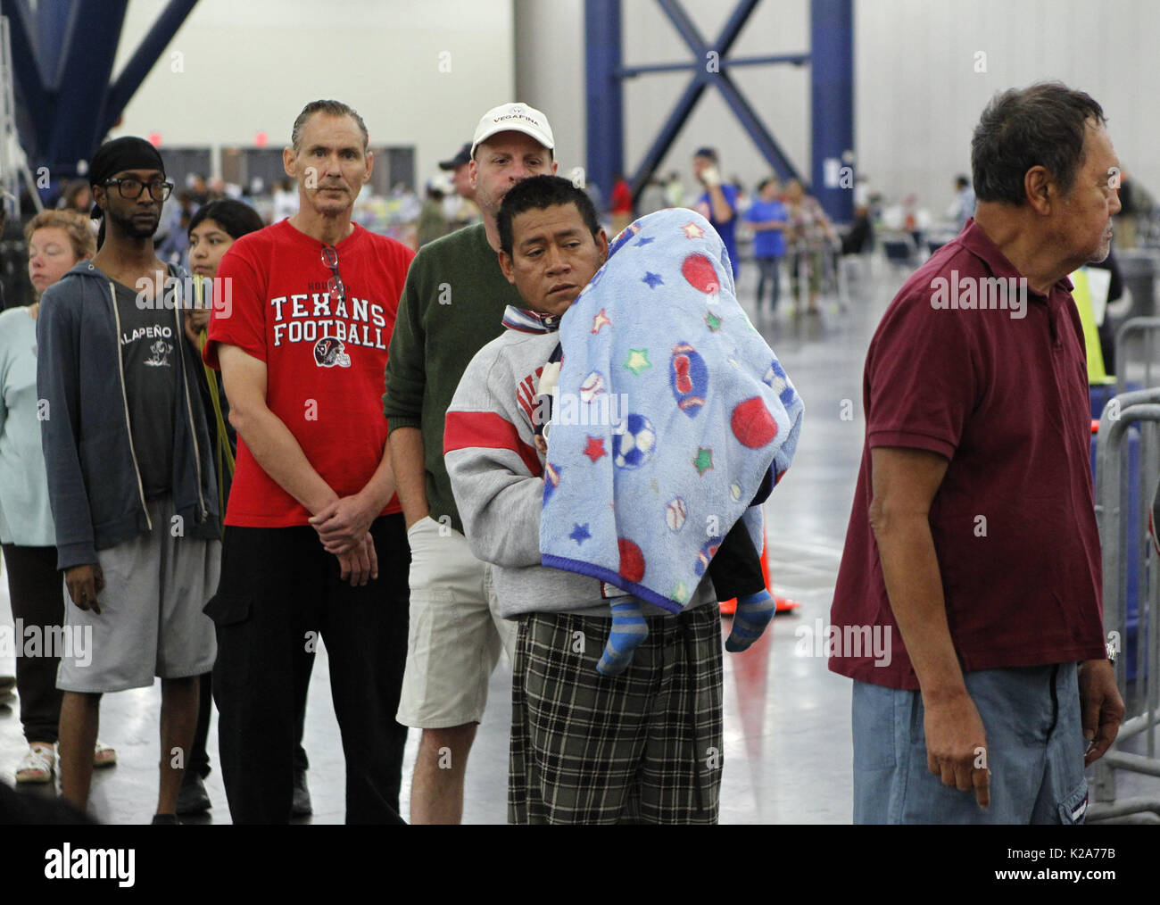 Houston, USA. 30 Aug, 2017. Die Menschen warten in Einklang Essen bei George Brown Convention Center, das als Schutz in Houston, Texas, in den Vereinigten Staaten eröffnet wurde, am 12.08.30., 2017. Das Amerikanische Rote Kreuz schätzt, dass mehr als 17.000 Texans Montag Nacht in 45 Notunterkünften öffnen über den Zustand verbracht, darunter etwa 9.000 Menschen in der Innenstadt von Houston George Brown Convention Center entfernt. Credit: Song Qiong/Xinhua/Alamy leben Nachrichten Stockfoto