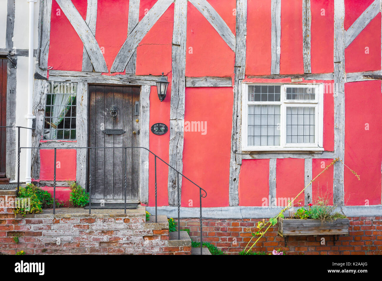 Lavenham Suffolk UK-Gebäude, äußeres Detail eines mittelalterlichen, in Fachwerk ausgeführten rosafarbenen Hauses im Suffolk-Dorf Lavenham, England, Großbritannien Stockfoto