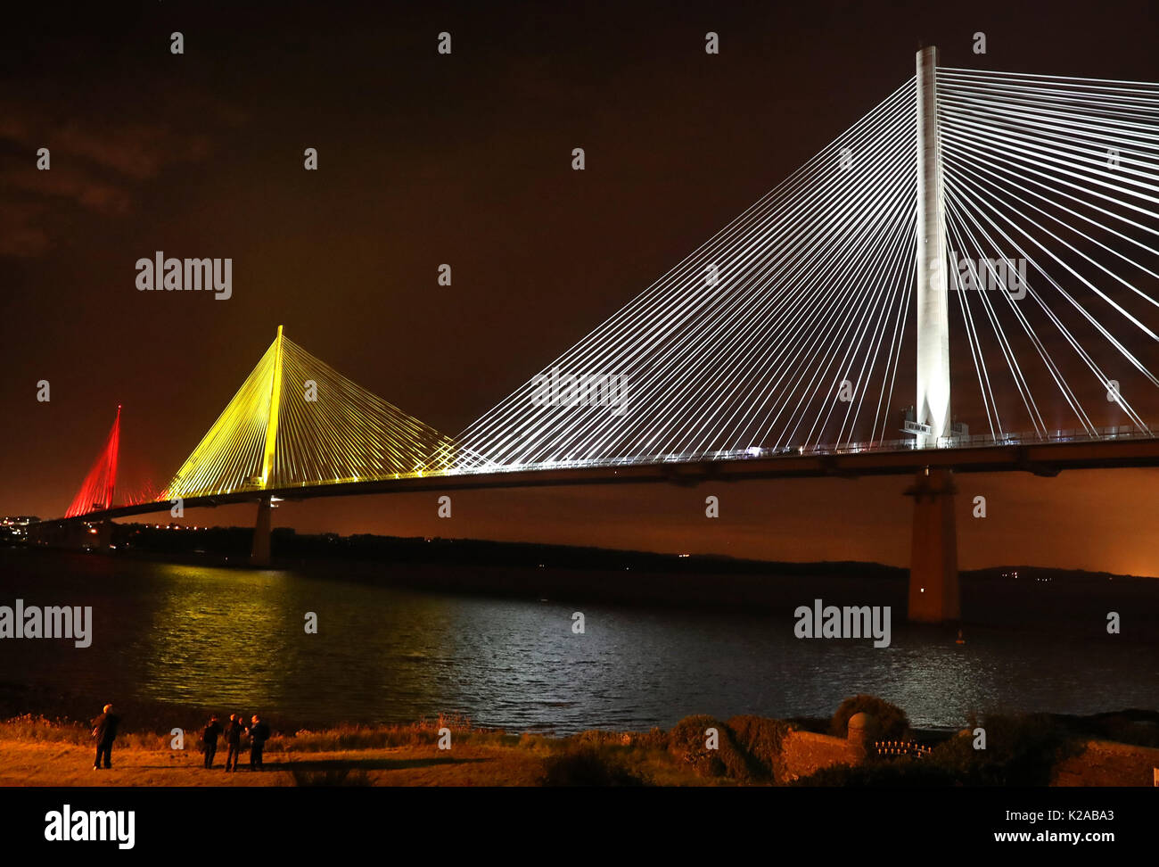 Ein Blick auf die neuen Queensferry Überfahrt von North Queensferry, Schottland gesehen, wie sie in einem feierlichen Übergabe vom Auftragnehmer für die schottische Regierung vor der offiziellen Eröffnung im nächsten Monat von Königin Elizabeth II. am 4. September leuchtet. Stockfoto