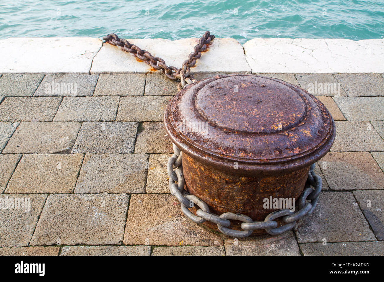 Rostige Poller und Metall Kette links im Hafen in Venedig, Italien Stockfoto