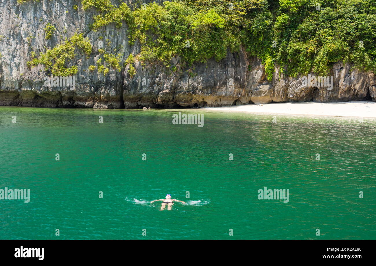 Mann entspannt im Wasser an einem tropischen Strand Stockfoto